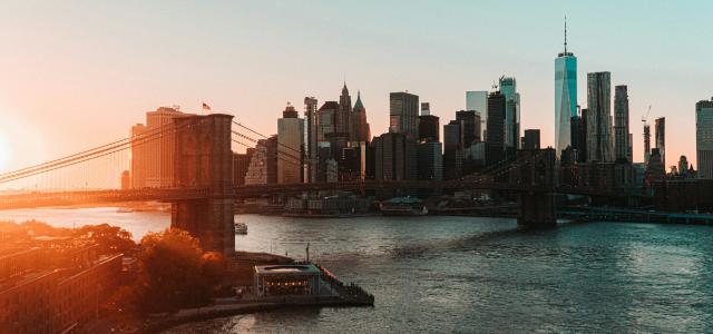 brown bridge over river near city buildings during daytime by Magnus Andersson courtesy of Unsplash.